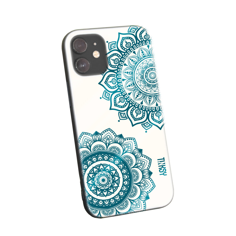 Phone case with detailed teal mandala designs on a light background